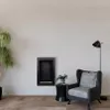 A modern living room setting with a fireplace, armchair, and plant. Voir les images du produit