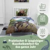 A child's bed with dinosaur-themed bedding, accompanied by icons indicating washing and drying instructions. Produktbild-Vorschau