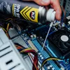 A hand is spraying a computer motherboard with a can of IPA cleaner. Podgląd zdjęcia produktu
