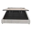 A beige upholstered bed frame with the slatted base lifted to reveal storage space underneath. Produktbild-Vorschau