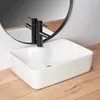 A white rectangular sink with a black faucet is placed on a wooden countertop, with a round mirror reflecting the faucet. Náhled obrázku produktu