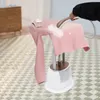 A person is steaming a pink garment on a garment steamer. Produktbild-Vorschau