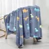 A dinosaur-themed blanket draped over a chair. Produktbild-Vorschau