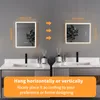 Two illuminated bathroom mirrors are mounted on a gray wall above sinks. Dimensions are indicated with text and arrows. Náhled obrázku produktu