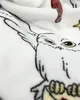 A close-up view of a white fleece blanket with a printed illustration of the owl Hedwig from Harry Potter. Produktbild-Vorschau