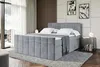 A modern bedroom with a large grey upholstered boxspring bed. Produktbild-Vorschau