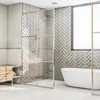 A modern bathroom with a freestanding bathtub, a glass-enclosed shower, and a wooden vanity. Produktbild-Vorschau