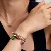 A person wearing jewelry, including a necklace and a bracelet with charms. Produktbild-Vorschau