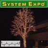 A tree decorated with many small lights at night, with a building in the background and a small inset image of a string of lights. Produktbild-Vorschau