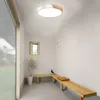 A modern hallway with a ceiling light, a plant, and wooden benches. Voir les images du produit