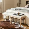 A tufted bench placed at the foot of a bed, with a cowhide rug in front. Podgląd zdjęcia produktu