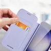A hand inserts a credit card into a purple phone case with a card slot. Produktbild-Vorschau