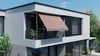 A modern building with a balcony featuring a retractable awning. Produktbild-Vorschau