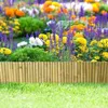 A close-up view of a garden border made of bamboo rolls, with colorful flowers and green grass in the background. Náhľad obrázku produktu