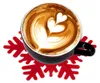 A black mug of coffee with latte art sits on a red snowflake coaster. Náhled obrázku produktu