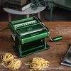 A green pasta maker sits on a wooden table with nests of fresh pasta in front of it. Náhľad obrázku produktu