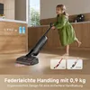 A young girl is using a vacuum cleaner in a kitchen. Voir les images du produit