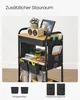 A multi-tiered rolling cart filled with various items, including books, jars, scissors, a picture frame, and a small plant. The cart is shown in a well-lit indoor setting. Produktbild-Vorschau