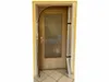 A dust protection door is shown installed in a doorway, with a wooden door behind it. Produktbild-Vorschau