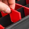 A hand is shown inserting a red divider into a black compartmentalized storage box. Produktbild-Vorschau