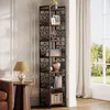A tall, narrow corner bookshelf filled with decorative items and books, placed in a living room setting next to a window with curtains. Podgląd zdjęcia produktu