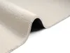 A close-up, angled view of a beige rug, showing its soft texture and the underside where it is folded. Produktbild-Vorschau