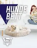 A woman sits on a couch next to a dog bed with a dog in it. Text overlays the image. Produktbild-Vorschau
