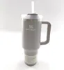 A gray Stanley Quencher H2.0 Flowstate tumbler with a straw and handle, shown against a white background. Produktbild-Vorschau