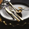 A close-up shot of gold cutlery on a black plate. Anteprima dell’immagine prodotto