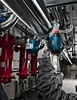 A person is using a Bosch impact wrench to tighten a pipe fitting in an industrial setting. Produktbild-Vorschau