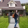 A woman stands in front of a house, holding a gate open. Produktbild-Vorschau