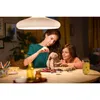 A woman and a child are sitting at a table, sewing a stuffed bunny. Produktbild-Vorschau
