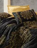 A close-up view of a bedding set with a black base and gold mandala patterns, featuring a yellow pillow in the background. Produktbild-Vorschau
