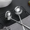 Two stainless steel ladles are placed on a black cooling rack, with a gray cloth underneath. Produktbild-Vorschau
