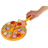 A hand is holding a pizza slicer and lifting a slice of a toy pizza. Podgląd zdjęcia produktu