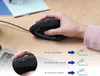 A hand holding a black ergonomic mouse on a wooden desk, with a laptop and notebook in the background. There are also diagrams illustrating DPI settings. Produktbild-Vorschau