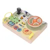 A wooden toy steering wheel and dashboard for toddlers, featuring various interactive elements. Náhled obrázku produktu