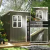 A dark gray metal garden shed with a white-trimmed window and an open door, set in a garden with plants and trees. Inset images highlight the window and ventilation openings. Produktbild-Vorschau