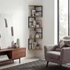 A corner shelf unit is displayed in a living room setting next to a chair and a cabinet. Anteprima dell’immagine prodotto