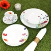 A set of porcelain dishes with a floral pattern is arranged on a green grassy surface. Produktbild-Vorschau