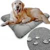 A golden retriever dog is lying on a gray dog mat. A close-up inset shows water droplets on the mat's fabric. Voir les images du produit