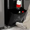 A person's foot is stepping on the pedal of a black trash can, with bottles inside. Produktbild-Vorschau
