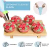 Cupcakes decorated with frosting roses and leaves, displayed on a wooden stand. Produktbild-Vorschau