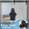A girl stands in front of a sliding barn door, looking into a bedroom where a child is sleeping. Náhled obrázku produktu