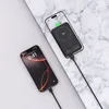 Two smartphones are shown, one charging wirelessly with a power bank, and another connected via cable. Produktbild-Vorschau