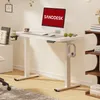 A modern home office setup featuring a white standing desk with a computer, accessories, and a bookshelf in the background. Podgląd zdjęcia produktu