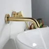A close-up shot of a gold-colored wall-mounted faucet with water flowing into a white sink. Podgląd zdjęcia produktu