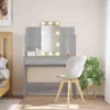 A vanity table with a lighted mirror and a chair in a bedroom setting. Produktbild-Vorschau