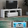 A modern white TV stand with a television and electronic devices. Anteprima dell’immagine prodotto