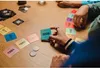 People playing a card game with year-themed cards on a wooden table. Anteprima dell’immagine prodotto